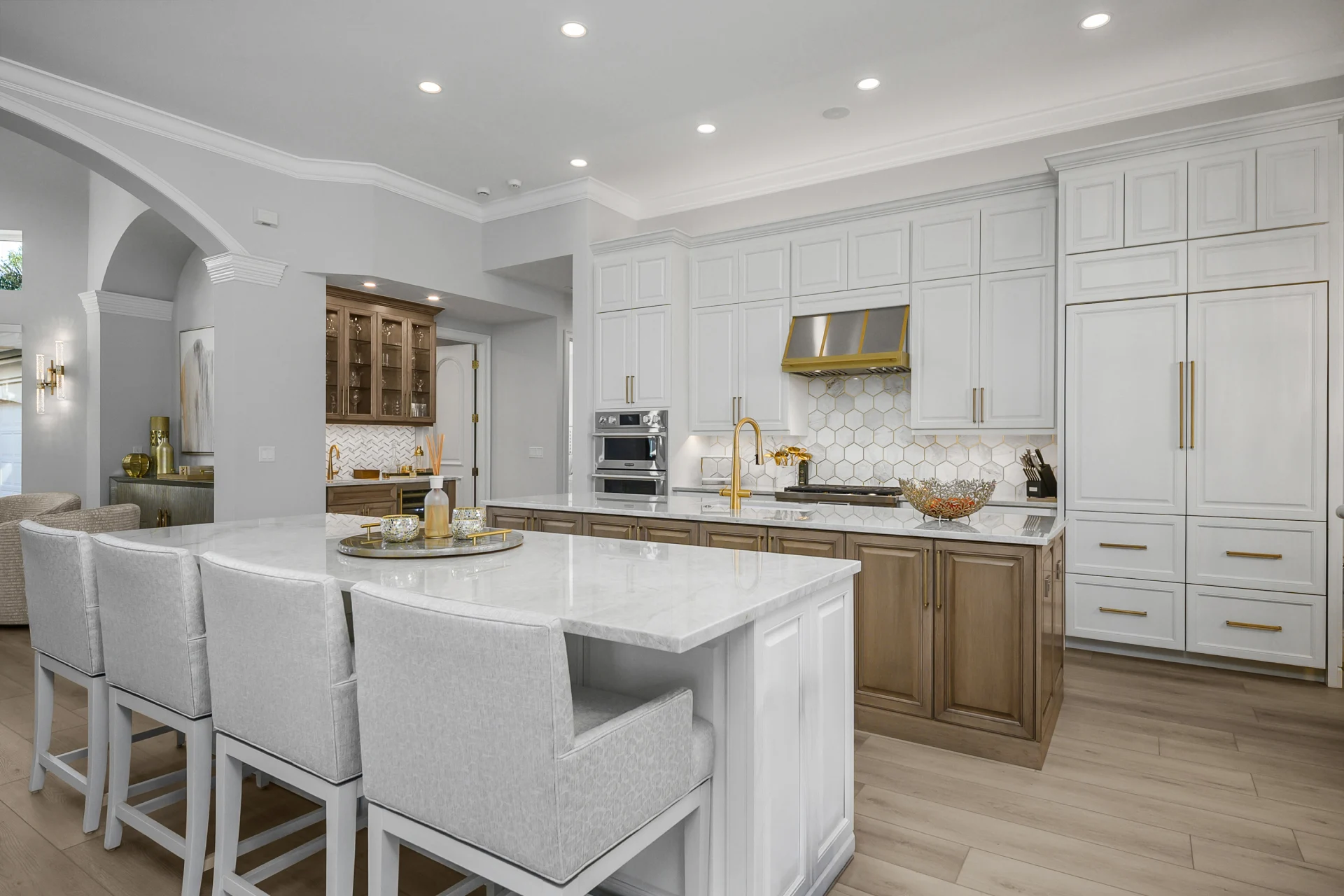 A modern kitchen featuring white cabinets and a spacious center island for cooking and dining.